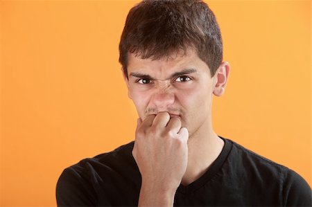 Frsturated Latino teen with knuckles in his mouth Stock Photo - Budget Royalty-Free & Subscription, Code: 400-04328154