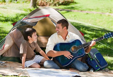 father son camping woods - Father playing guitar with his son Stock Photo - Budget Royalty-Free & Subscription, Code: 400-04328337