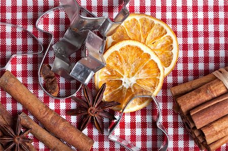 Dried Orange with cinnamon and anise on chequered cloth with cookie cutters Photographie de stock - Aubaine LD & Abonnement, Code: 400-04329324
