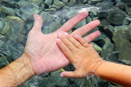 finger lakes - adult and children hands holding underwater wavy distorted Stock Photo - Budget Royalty-Free & Subscription, Code: 400-04329346