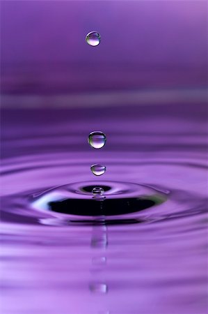 simsearch:400-05282643,k - A purple abstract background of a close up of transparent water drops falling in water, making beautifull ripples and flowing waves in the surface and showing the pure energy it creates. Small depth of field. Foto de stock - Super Valor sin royalties y Suscripción, Código: 400-04320609