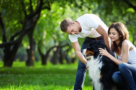 A young couple walking a dog in the park Stock Photo - Budget Royalty-Free & Subscription, Code: 400-04320872