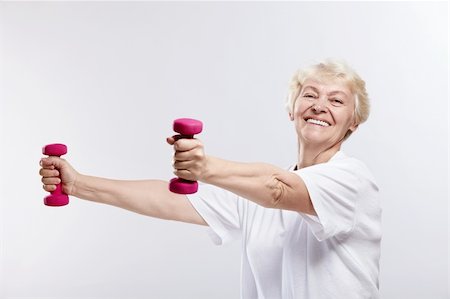 powerful mature female muscles - Mature woman smiling with dumbbells on white background Stock Photo - Budget Royalty-Free & Subscription, Code: 400-04320907