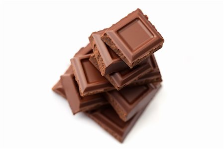 schokoladensüchtig - Pieces of dark chocolate stacked, shallow dof, isolated on white. Stockbilder - Microstock & Abonnement, Bildnummer: 400-04321636