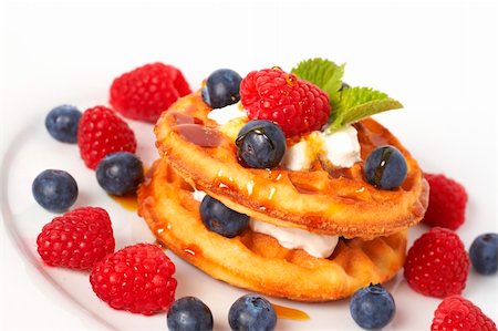 simsearch:400-04043868,k - Belgian waffles with fresh raspberries, blueberries, mint leaves and cream on white plate Stock Photo - Budget Royalty-Free & Subscription, Code: 400-04321847