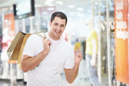 einkaufssüchtiger (männlich) - A young man with the shopping and credit card at the store Stockbilder - Microstock & Abonnement, Bildnummer: 400-04322101