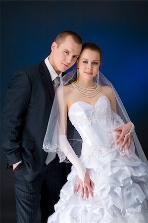 simsearch:400-04606804,k - Bride and groom studio portrait over blue background Fotografie stock - Microstock e Abbonamento, Codice: 400-04323362