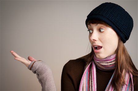surprised beautiful young woman in winter clothes holding something in her hand Fotografie stock - Microstock e Abbonamento, Codice: 400-04323526