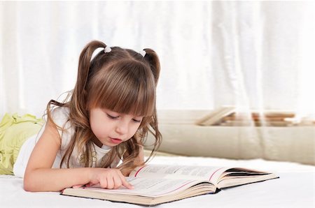 fotostok_pdv (artist) - Lovely little girl, reading a book, on the bed Foto de stock - Royalty-Free Super Valor e Assinatura, Número: 400-04334330