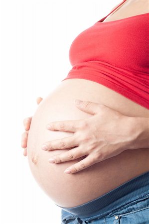 simsearch:400-05887749,k - Pregnant woman holding her belly with hands over white background Stock Photo - Budget Royalty-Free & Subscription, Code: 400-04334842