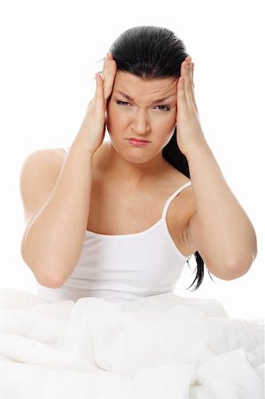 simsearch:400-07485414,k - Young caucasian female sitting on bed. She have terrible headache (illness or hangover). Isolated on white Fotografie stock - Microstock e Abbonamento, Codice: 400-04335057