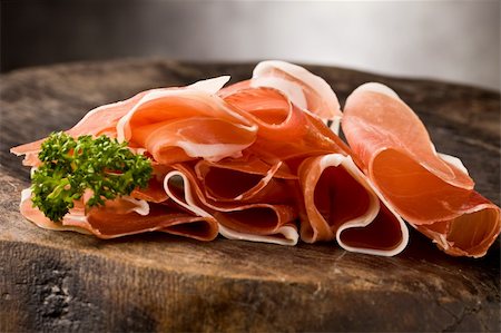 smoked ham - photo of delicious sliced bacon on wooden table with parsley Photographie de stock - Aubaine LD & Abonnement, Code: 400-04335388