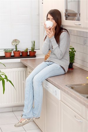 simsearch:400-04335902,k - Young beautiful woman having coffee or tea in the kitchen Photographie de stock - Aubaine LD & Abonnement, Code: 400-04335904