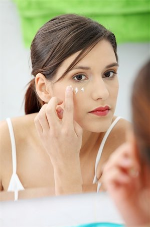 simsearch:400-04129614,k - Beautiful woman applying cream on face at bathroom Stock Photo - Budget Royalty-Free & Subscription, Code: 400-04335993