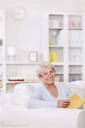 Mature attractive woman with a book on the couch Stock Photo - Budget Royalty-Free & Subscription, Code: 400-04336146