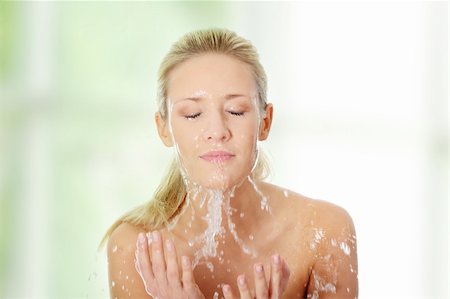 Young beautiful blond female washing her face with clear water Foto de stock - Super Valor sin royalties y Suscripción, Código: 400-04336143