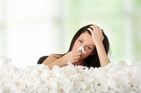 sneezing into hands - Young woman in lot of tissues around Photographie de stock - Aubaine LD & Abonnement, Code: 400-04336188