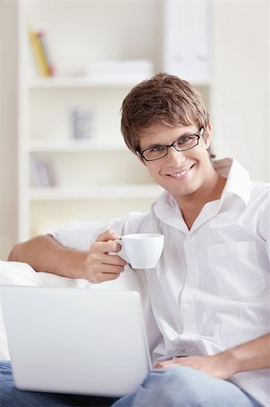 Attractive young man with a cup and laptop Stock Photo - Budget Royalty-Free & Subscription, Code: 400-04336270