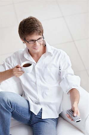 A man with a cup of coffee switch TV channels Photographie de stock - Aubaine LD & Abonnement, Code: 400-04336287