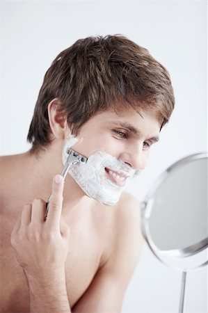 Young man shaving at the mirror Stock Photo - Budget Royalty-Free & Subscription, Code: 400-04336309