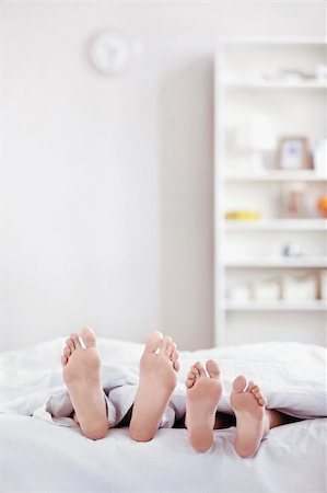 sleeping man foot - Pair of legs protruding from under the blanket Photographie de stock - Aubaine LD & Abonnement, Code: 400-04336493