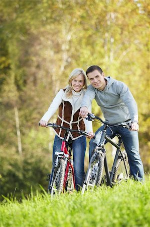 simsearch:400-04336561,k - Young couple on bicycles in the park Fotografie stock - Microstock e Abbonamento, Codice: 400-04336534