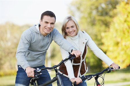 simsearch:400-04336561,k - Attractive couple on bicycles in the park Fotografie stock - Microstock e Abbonamento, Codice: 400-04336535