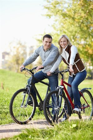 simsearch:400-04336561,k - The happy couple on bicycles in the park Fotografie stock - Microstock e Abbonamento, Codice: 400-04336539