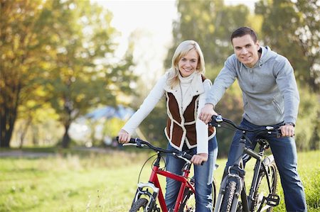 simsearch:400-04336561,k - A happy young couple on bicycles in the park Fotografie stock - Microstock e Abbonamento, Codice: 400-04336531