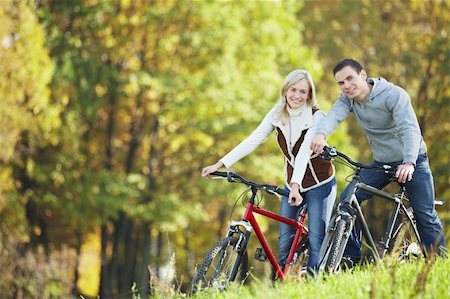 simsearch:400-04336549,k - Attractive couple on bicycles in the park Fotografie stock - Microstock e Abbonamento, Codice: 400-04336533