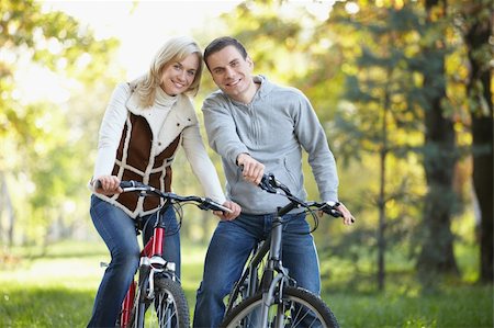 simsearch:400-04336549,k - Young couple on bicycles in the park Fotografie stock - Microstock e Abbonamento, Codice: 400-04336546