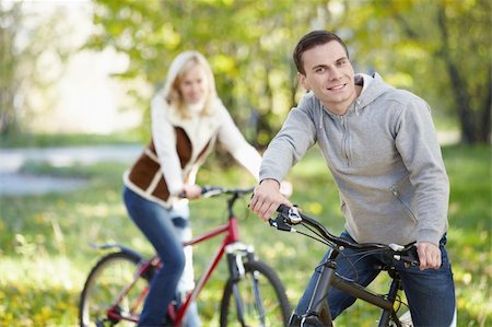 simsearch:400-04336561,k - A man on a bicycle in the park in the foreground Fotografie stock - Microstock e Abbonamento, Codice: 400-04336549