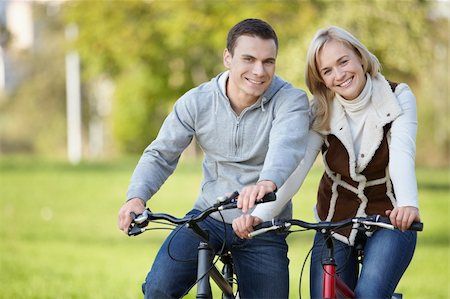 simsearch:400-04336561,k - Young couple on bicycles in the park Fotografie stock - Microstock e Abbonamento, Codice: 400-04336541