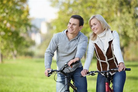 simsearch:400-04336561,k - Smiling couple on bicycles in the park Fotografie stock - Microstock e Abbonamento, Codice: 400-04336543