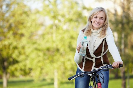 simsearch:400-04336561,k - Attractive girl on a bicycle in the autumn park Fotografie stock - Microstock e Abbonamento, Codice: 400-04336558