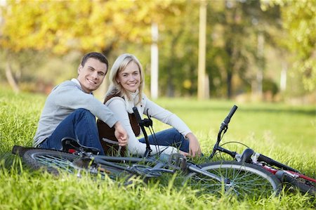 simsearch:400-04336549,k - Couple with bicycles resting on the grass Fotografie stock - Microstock e Abbonamento, Codice: 400-04336550