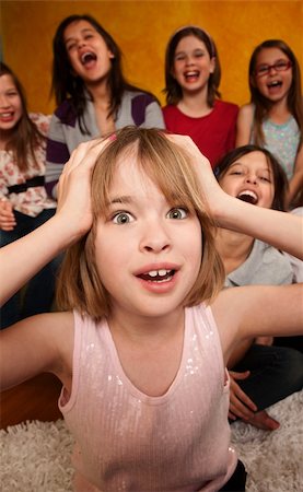 Little Caucasian girl with hands on head while friends laugh Stock Photo - Budget Royalty-Free & Subscription, Code: 400-04339483