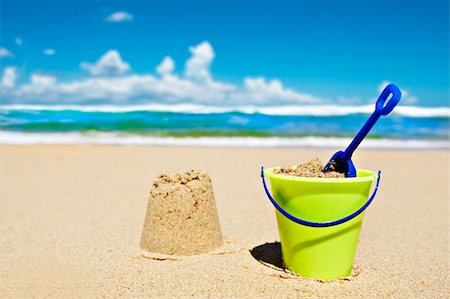 Toy bucket and shovel on the beach on a sunny day Fotografie stock - Microstock e Abbonamento, Codice: 400-04330119