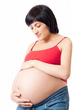 simsearch:400-06849973,k - Pregnant woman embraces his stomach and looks to stomach over white background Stock Photo - Budget Royalty-Free & Subscription, Code: 400-04330289