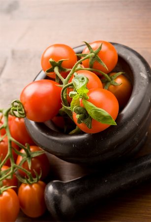 fräsen - photo of tomatoes inside a black mortar ready to be smashed for preparing tomatoe sauce Stockbilder - Microstock & Abonnement, Bildnummer: 400-04332414