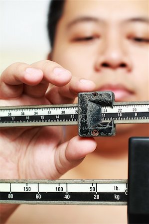 Man measuring weight on an old weighing scale Stock Photo - Budget Royalty-Free & Subscription, Code: 400-04333308