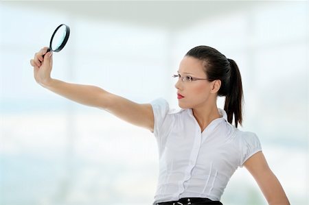 simsearch:400-04554899,k - Young attractive business woman looking into a magnifying glass Stock Photo - Budget Royalty-Free & Subscription, Code: 400-04333353