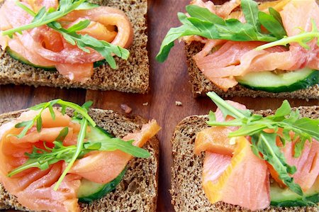 poco appetitoso - Sandwich with smoked salmon and arugula on a wooden board Photographie de stock - Aubaine LD & Abonnement, Code: 400-04344391
