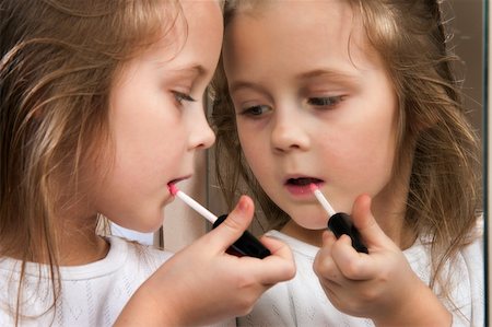 Little girl with lipstick at mirror Foto de stock - Super Valor sin royalties y Suscripción, Código: 400-04345084