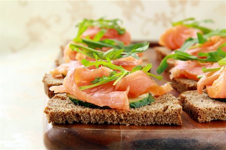poco appetitoso - Sandwich with smoked salmon and arugula on a wooden board Photographie de stock - Aubaine LD & Abonnement, Code: 400-04345128