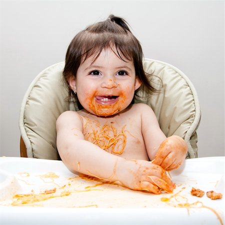 Happy baby having fun eating messy covered in Spaghetti Angel Hair Pasta red marinara tomato sauce. Stock Photo - Budget Royalty-Free & Subscription, Code: 400-04345317