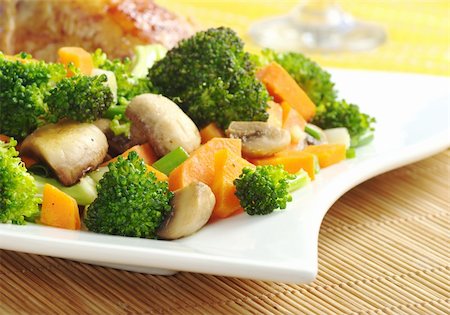 Fried vegetables (broccoli, mushroom, carrot, shallot) on white plate with chicken meat and wine glass in the background (Selective Focus, Focus on the vegetables in the front) Stock Photo - Budget Royalty-Free & Subscription, Code: 400-04345350