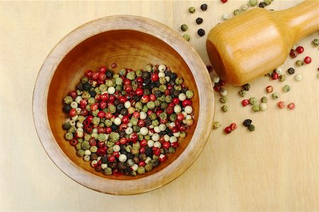simsearch:400-04846756,k - Black, red, green and white peppercorns in wooden mortar with pestle on wooden board photographed from above (Selective Focus, Focus on the peppercorns in the mortar) Stock Photo - Budget Royalty-Free & Subscription, Code: 400-04345420