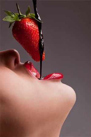 Beautiful girl eating a fresh red strawberry with chocolate sauce Stockbilder - Microstock & Abonnement, Bildnummer: 400-04345602