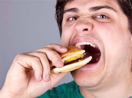 Cute boy eating hamburger. Studio shot. Stock Photo - Budget Royalty-Free & Subscription, Code: 400-04346633